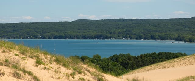 Sleeping Bear Dunes overlooking turquoise Lake Michigan with forested shoreline